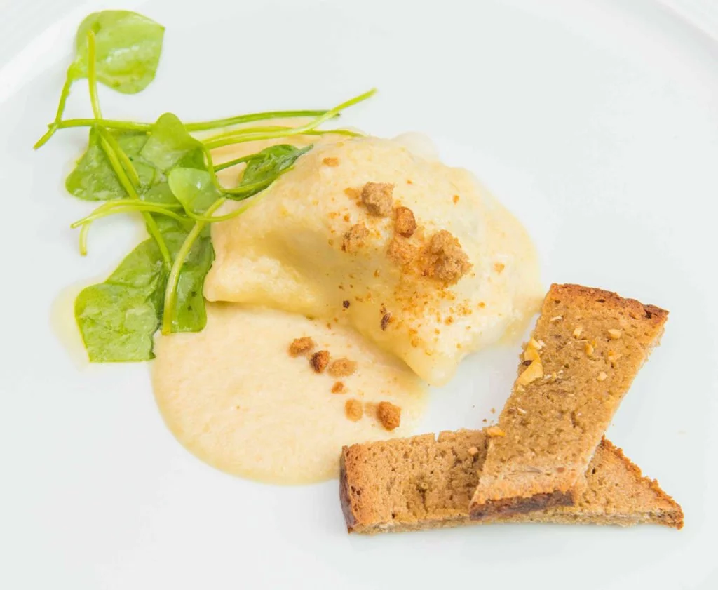 Fleischnudel mit Sauce und Knusperstreifen angerichtet